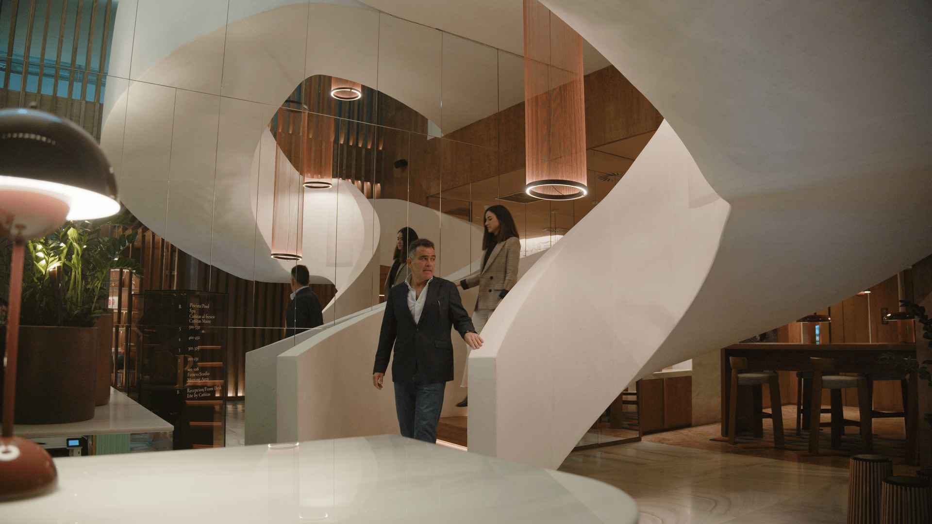 Escalera circular de hormigón armado blanco en el vestíbulo del hotel ME Málaga 