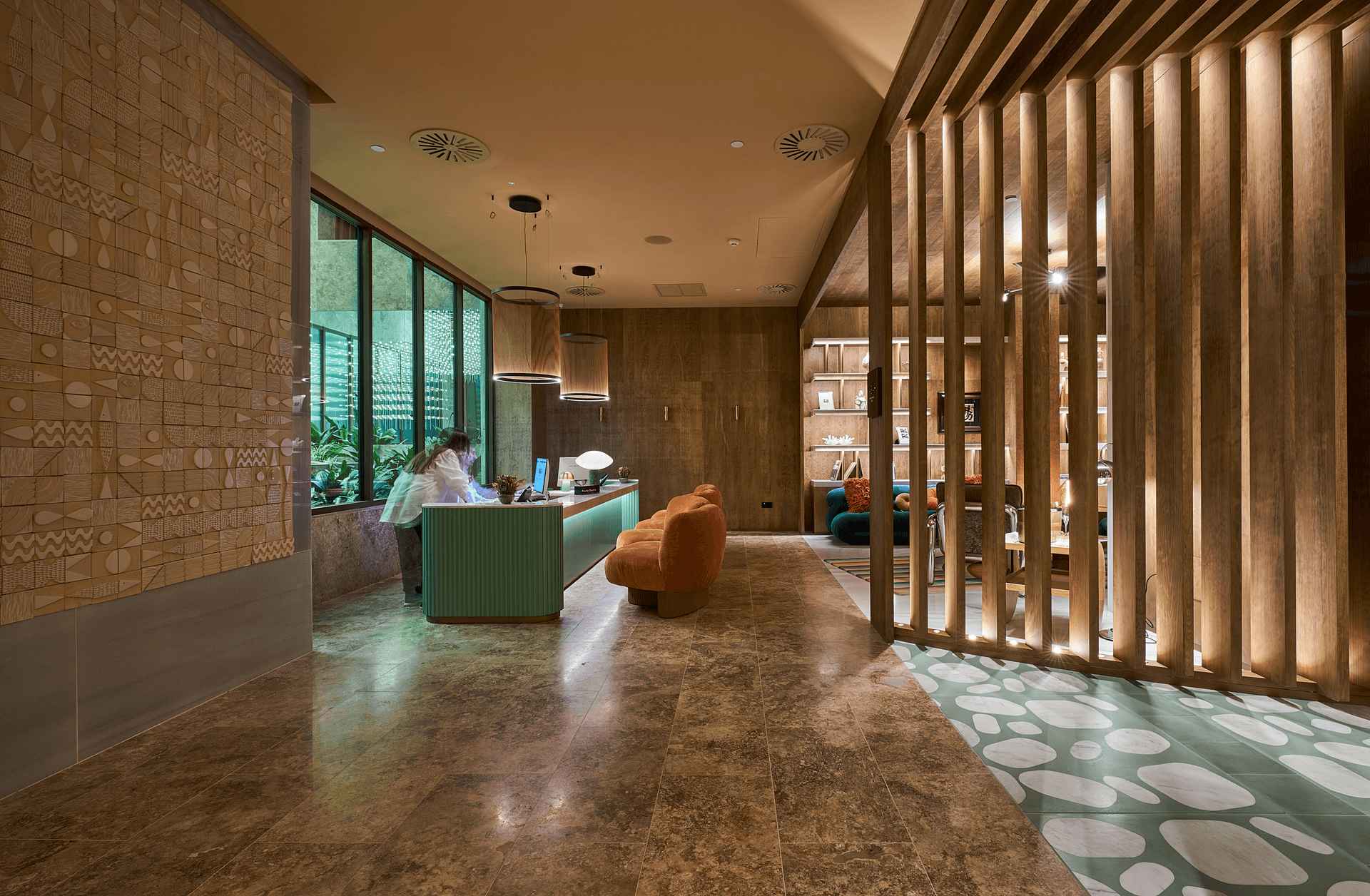 Lobby del hotel ME Málaga con lamas de madera, iluminación cálida, ventanales de marca STRUGAL y recepción de diseño contemporáneo
